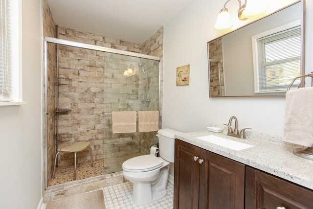 bathroom featuring toilet, a shower with door, vanity, and tile patterned flooring