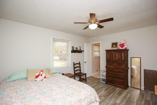 bedroom with hardwood / wood-style floors, a textured ceiling, and ceiling fan