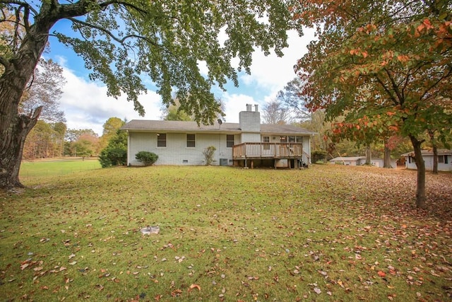 back of property featuring a yard, a chimney, crawl space, a deck, and brick siding