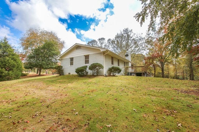 view of side of property featuring a wooden deck, a lawn, brick siding, and crawl space