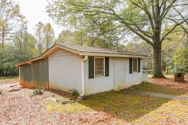 view of side of home with a shingled roof