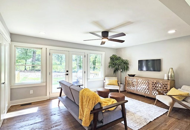 living room featuring visible vents, french doors, baseboards, wood finished floors, and a ceiling fan