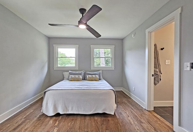 bedroom with dark wood-style floors, ceiling fan, and baseboards