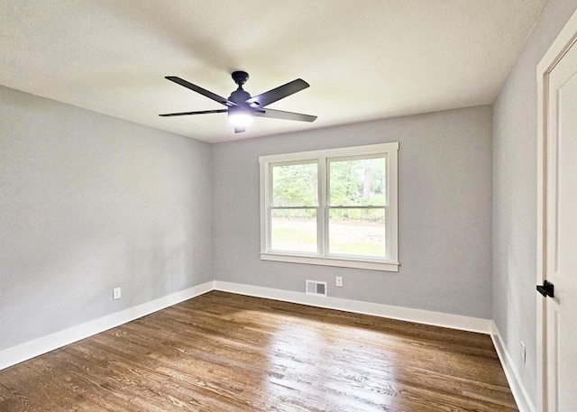 unfurnished room with wood finished floors, visible vents, ceiling fan, and baseboards