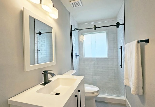 full bathroom with visible vents, toilet, a shower stall, and vanity