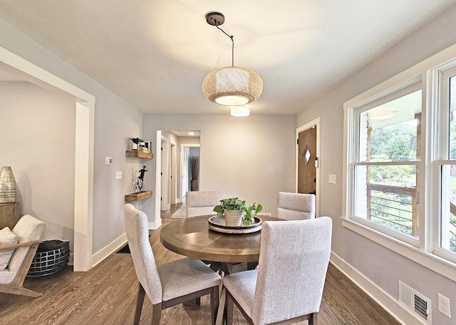 dining area featuring baseboards, visible vents, and dark wood-style flooring