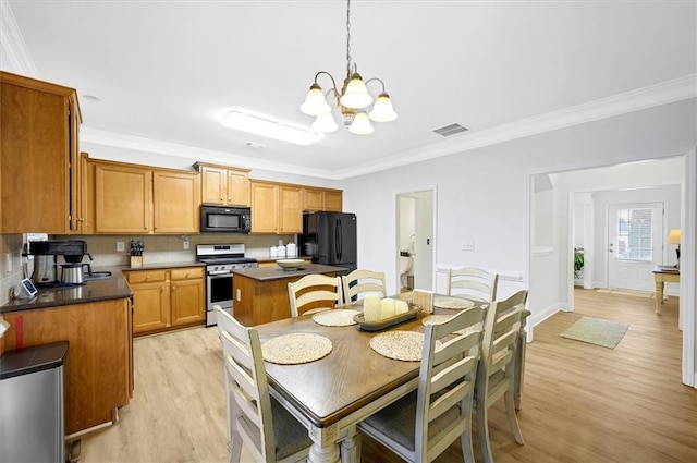 dining room featuring light hardwood / wood-style flooring, crown molding, and a chandelier