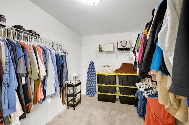 walk in closet with light carpet