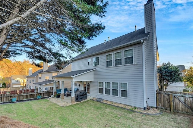 rear view of house featuring a yard and a patio area