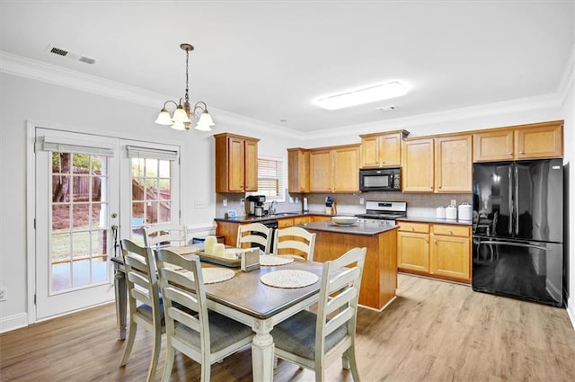 kitchen with crown molding, black appliances, a chandelier, light hardwood / wood-style floors, and hanging light fixtures