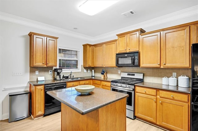 kitchen featuring black appliances, sink, crown molding, light hardwood / wood-style flooring, and a kitchen island