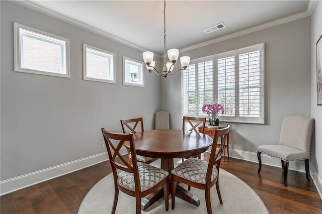 dining room featuring ornamental molding, visible vents, baseboards, and wood finished floors