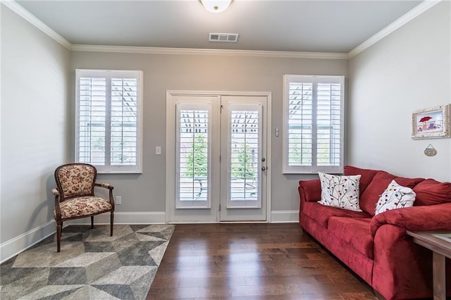 interior space featuring baseboards, crown molding, visible vents, and wood finished floors