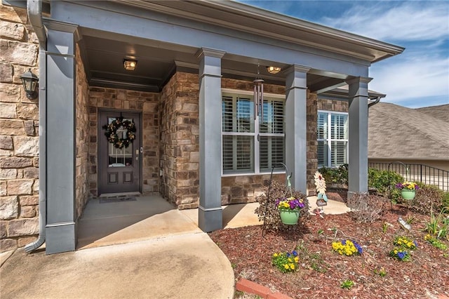 entrance to property featuring stone siding and covered porch