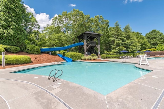 community pool featuring a patio area and a water slide