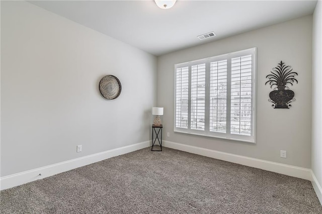 carpeted spare room with visible vents and baseboards