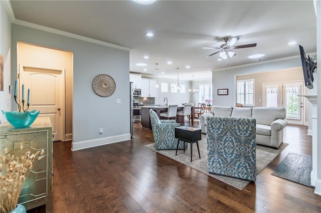 living area with dark wood-style floors, a ceiling fan, and crown molding