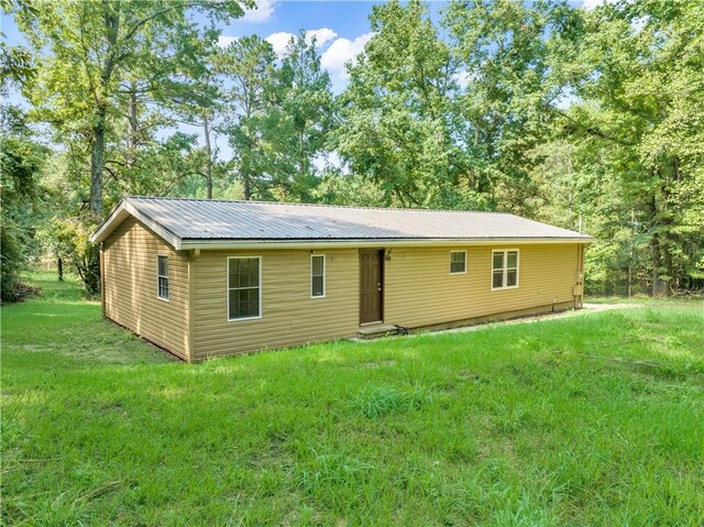 rear view of property featuring a yard