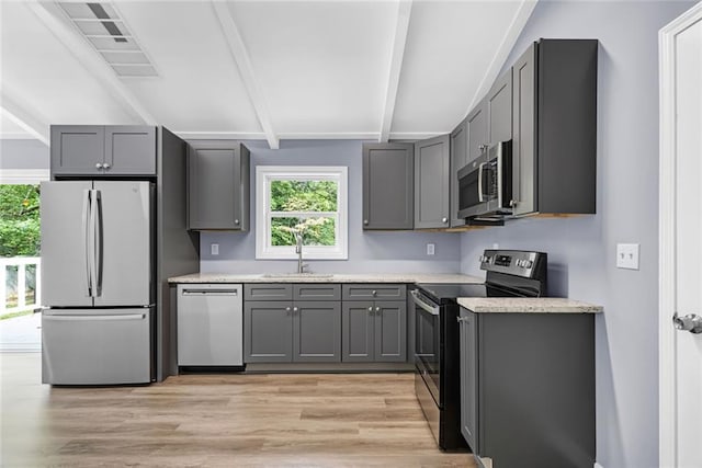 kitchen featuring appliances with stainless steel finishes, a sink, and gray cabinetry