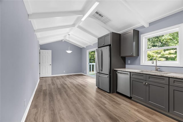 kitchen featuring appliances with stainless steel finishes, light wood-type flooring, sink, lofted ceiling with beams, and gray cabinets