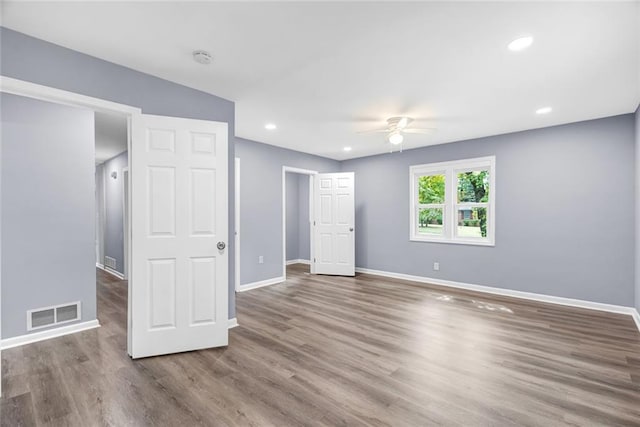 unfurnished room with baseboards, visible vents, wood finished floors, and recessed lighting