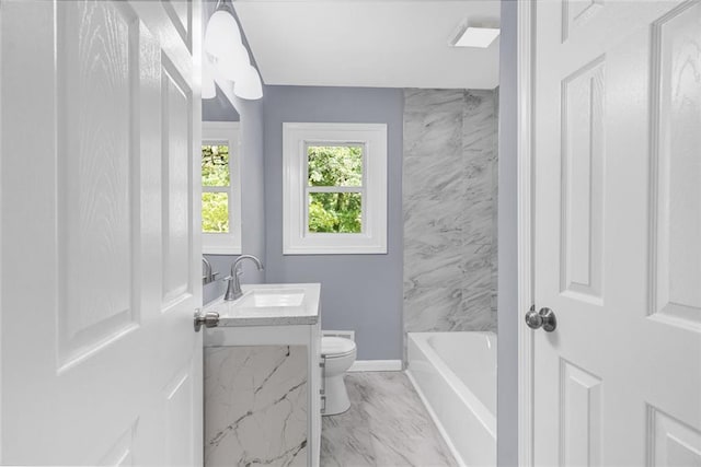 bathroom featuring a tub to relax in, baseboards, toilet, marble finish floor, and vanity