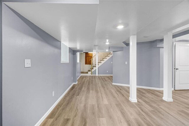 basement with light hardwood / wood-style flooring