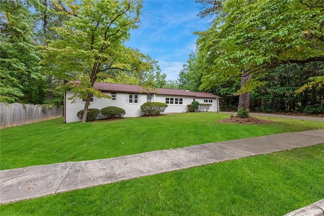 ranch-style house with fence and a front lawn