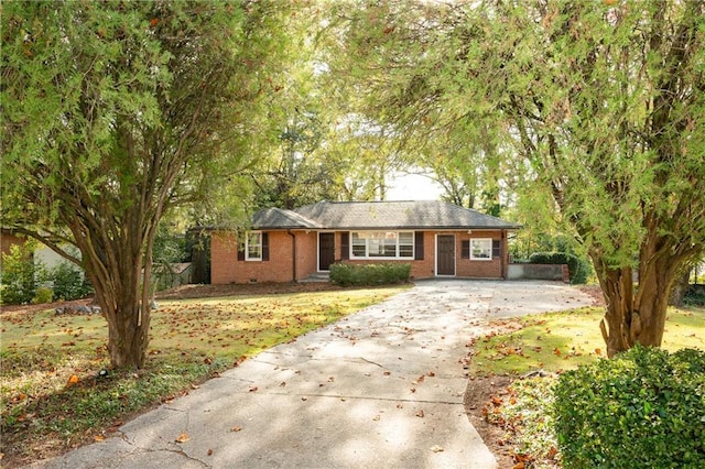 ranch-style home with concrete driveway and a front yard