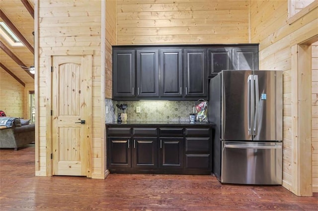 1102 Soque Wilderness Rd, Clarkesville, GA 30523 - kitchen with freestanding refrigerator, wooden walls, dark countertops, dark wood-type flooring, and tasteful backsplash