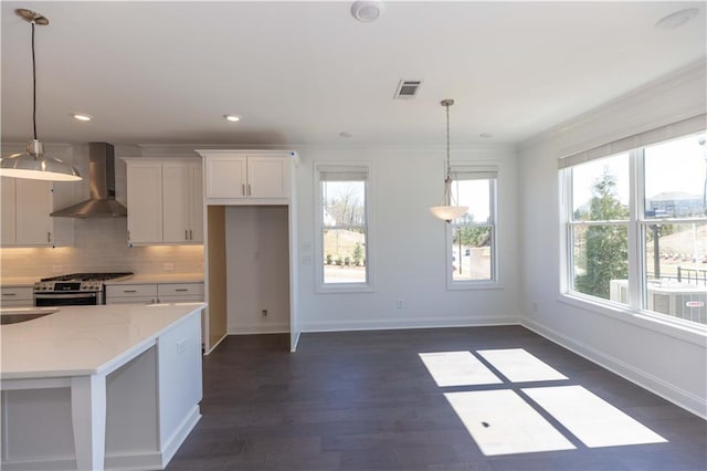 709 Dodd Ln Unit 165, Buford, GA 30518 - kitchen with wall chimney exhaust hood, stainless steel gas range, white cabinets, backsplash, and baseboards