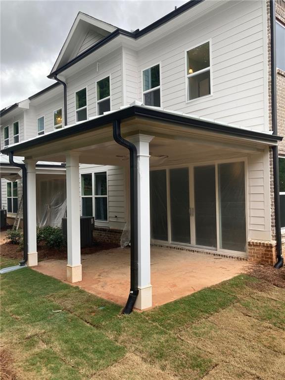 709 Dodd Ln Unit 165, Buford, GA 30518 - rear view of property with a patio, brick siding, and a lawn