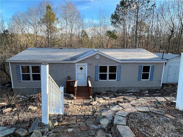 manufactured / mobile home featuring entry steps and a shingled roof