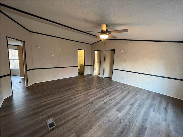 unfurnished room featuring visible vents, lofted ceiling, wood finished floors, and a ceiling fan