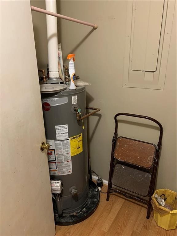 utility room featuring gas water heater and electric panel