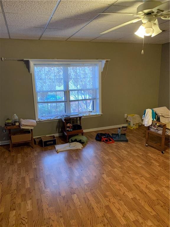 playroom with hardwood / wood-style flooring, a paneled ceiling, and ceiling fan