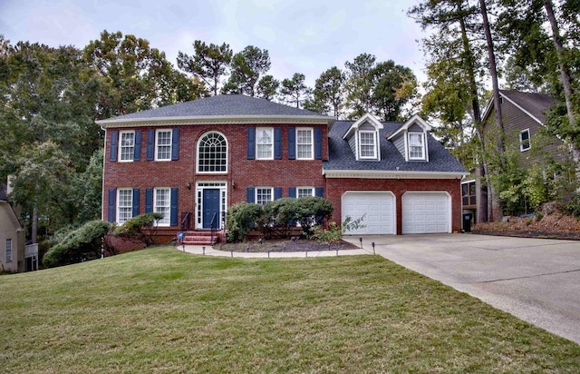 colonial inspired home featuring a garage and a front yard