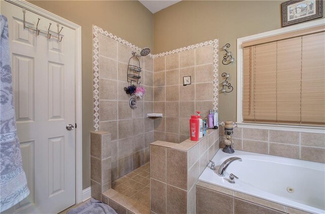 full bathroom featuring a tub with jets and tiled shower
