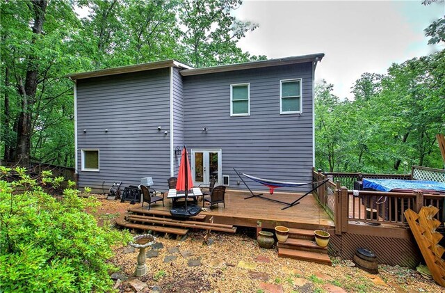 rear view of property featuring a deck and french doors