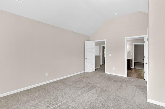unfurnished bedroom with baseboards, carpet, and high vaulted ceiling