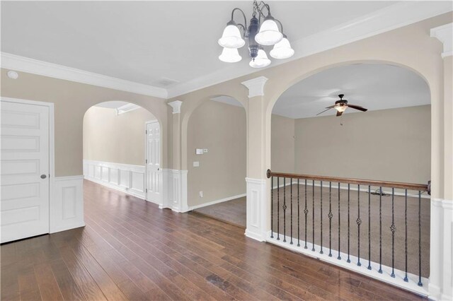 unfurnished room with arched walkways, ornamental molding, ceiling fan with notable chandelier, and hardwood / wood-style floors