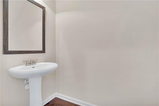 bathroom with baseboards and wood finished floors
