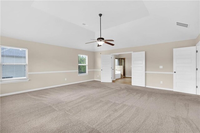 unfurnished bedroom with visible vents, vaulted ceiling, carpet floors, baseboards, and ensuite bathroom