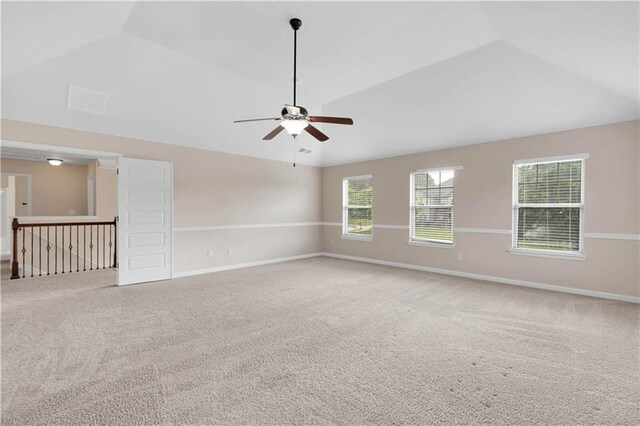 unfurnished room featuring carpet flooring, ceiling fan, vaulted ceiling, and baseboards