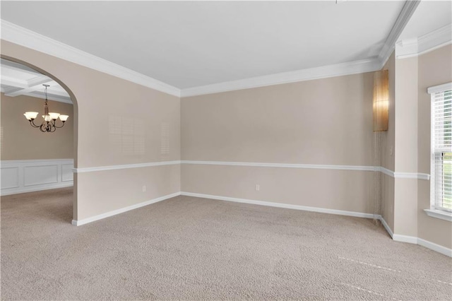 carpeted spare room with arched walkways, an inviting chandelier, and ornamental molding