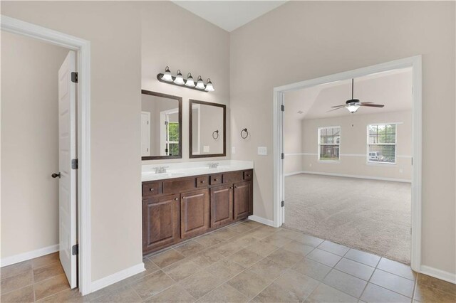 bathroom featuring baseboards, a ceiling fan, a sink, and double vanity