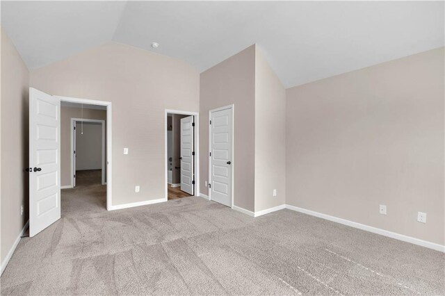 unfurnished bedroom featuring baseboards, carpet flooring, and vaulted ceiling