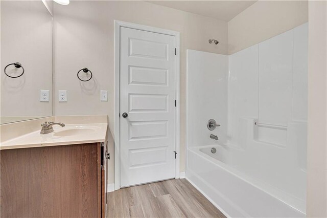 bathroom with vanity, shower / bathtub combination, and wood finished floors