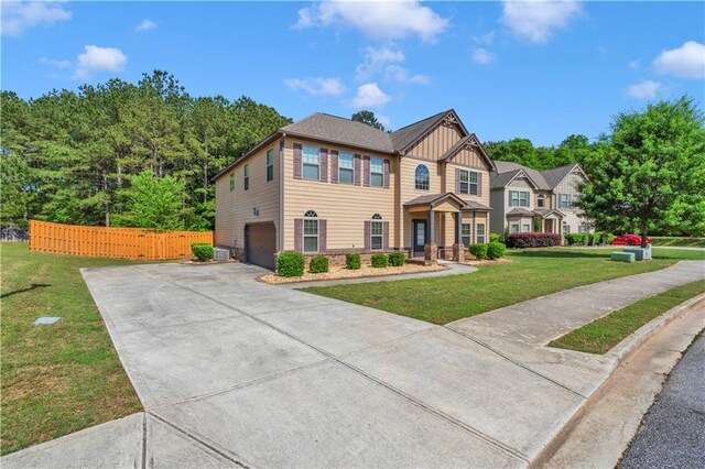 view of front of property featuring fence, a garage, board and batten siding, a front yard, and driveway