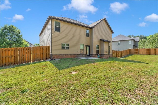 back of house featuring a fenced backyard and a yard